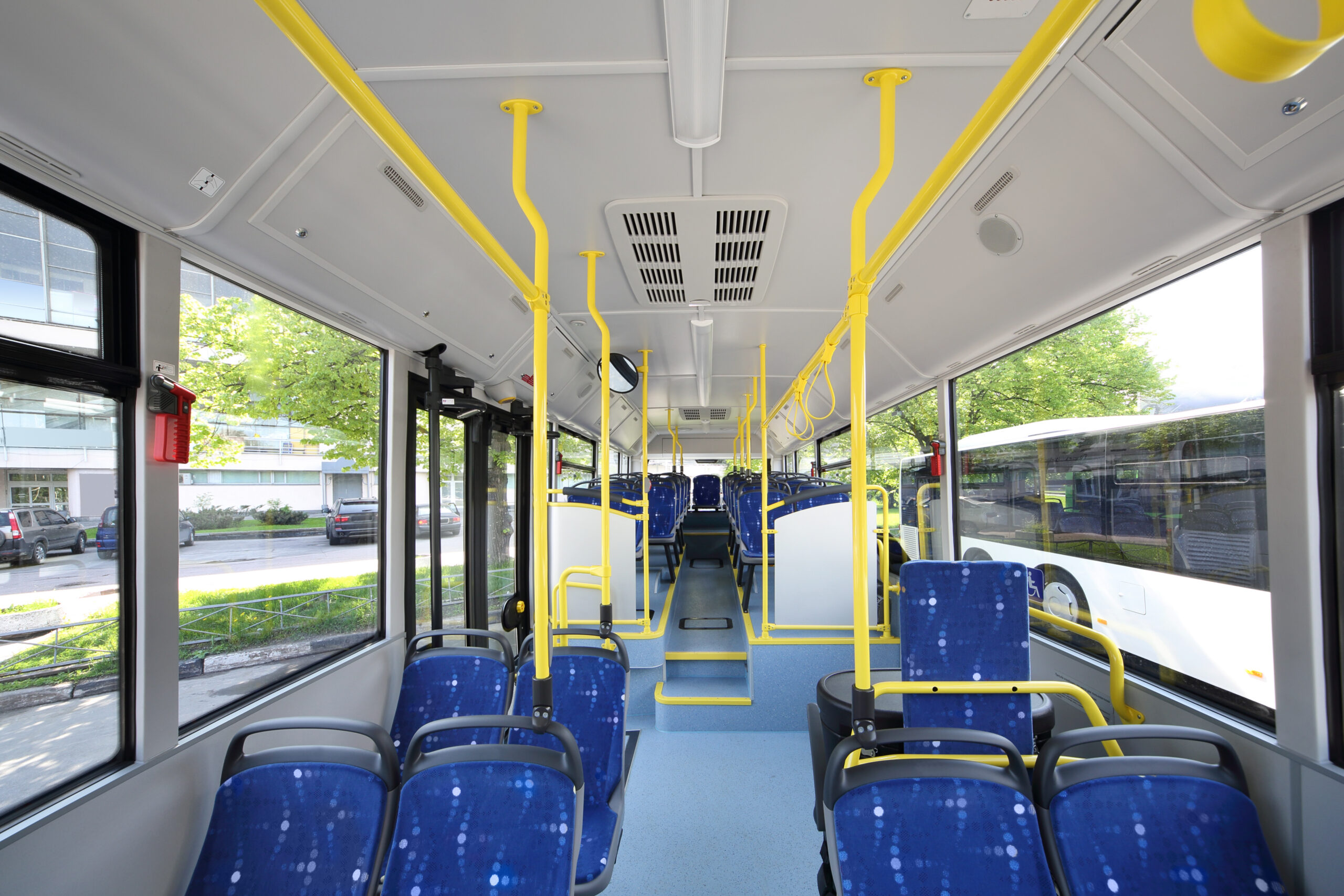 Vandalism-resistant transit windows installed inside a public transportation bus.
