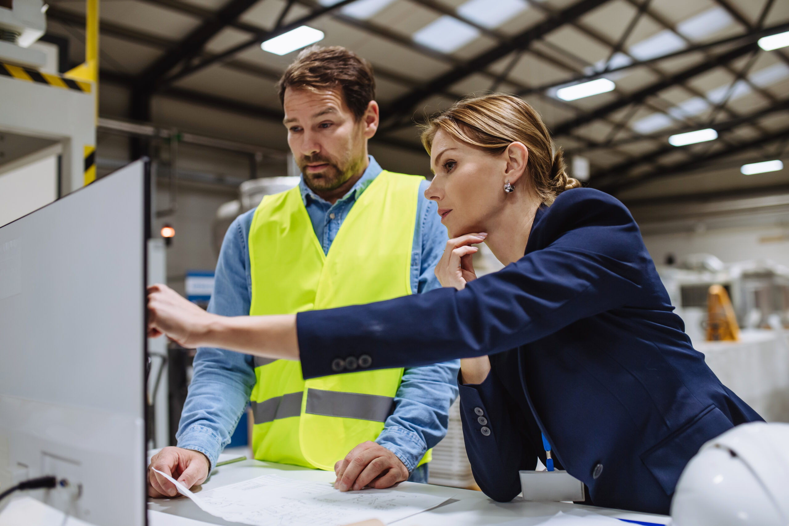 OEM engineers reviewing technical specifications in a manufacturing facility