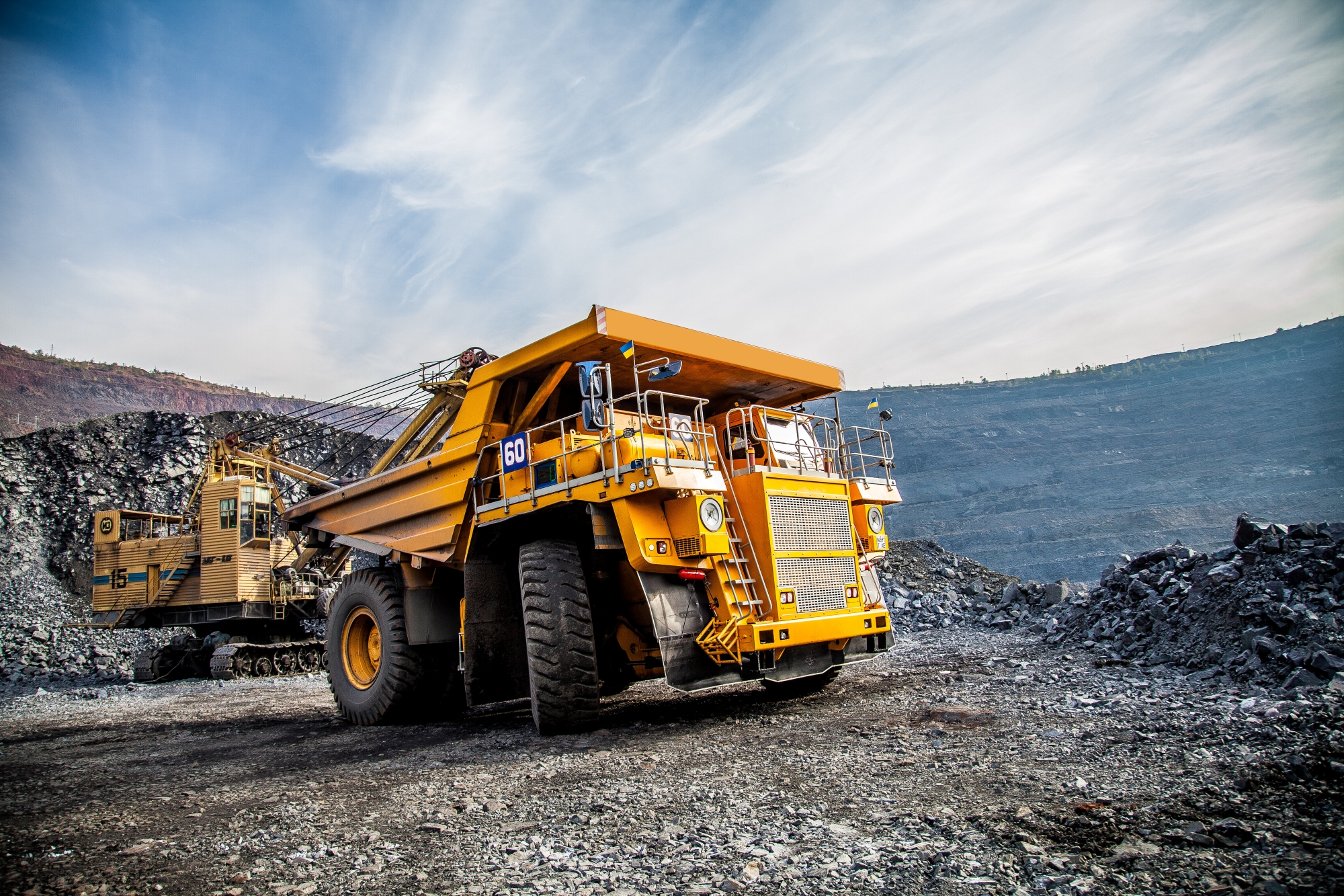 Mining haul truck with protective cab windows operating in an open-pit mine